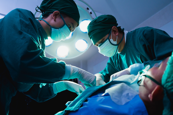 doctor team operate surgery patient under lighting in operating room